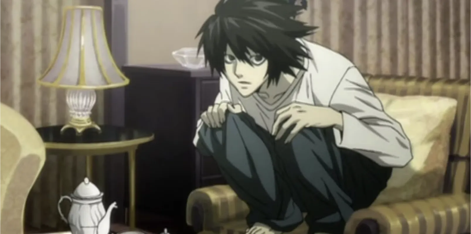 A picture of L from the anime Death Note. He's squatted in a chair so he's curled up in a ball.